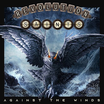 Album artwork for the album Against The Winds by Revolution Saints. It is created using moody dark greys and blues with a bird in the centre with fire for eyes, the bird is flying towards you with sea and rocks in the background
